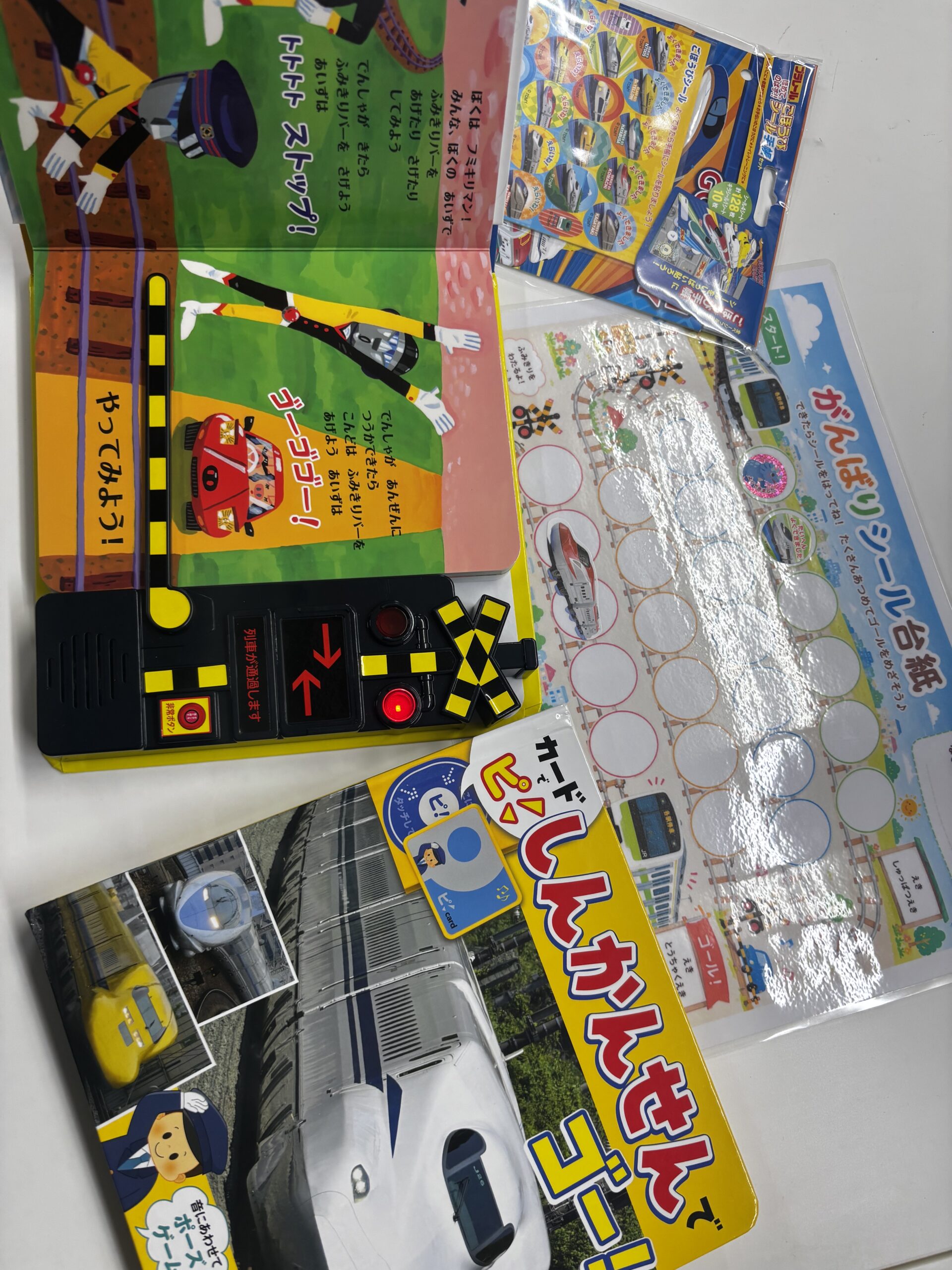 電車の絵本、踏切のおもちゃ、シール台紙などの教材