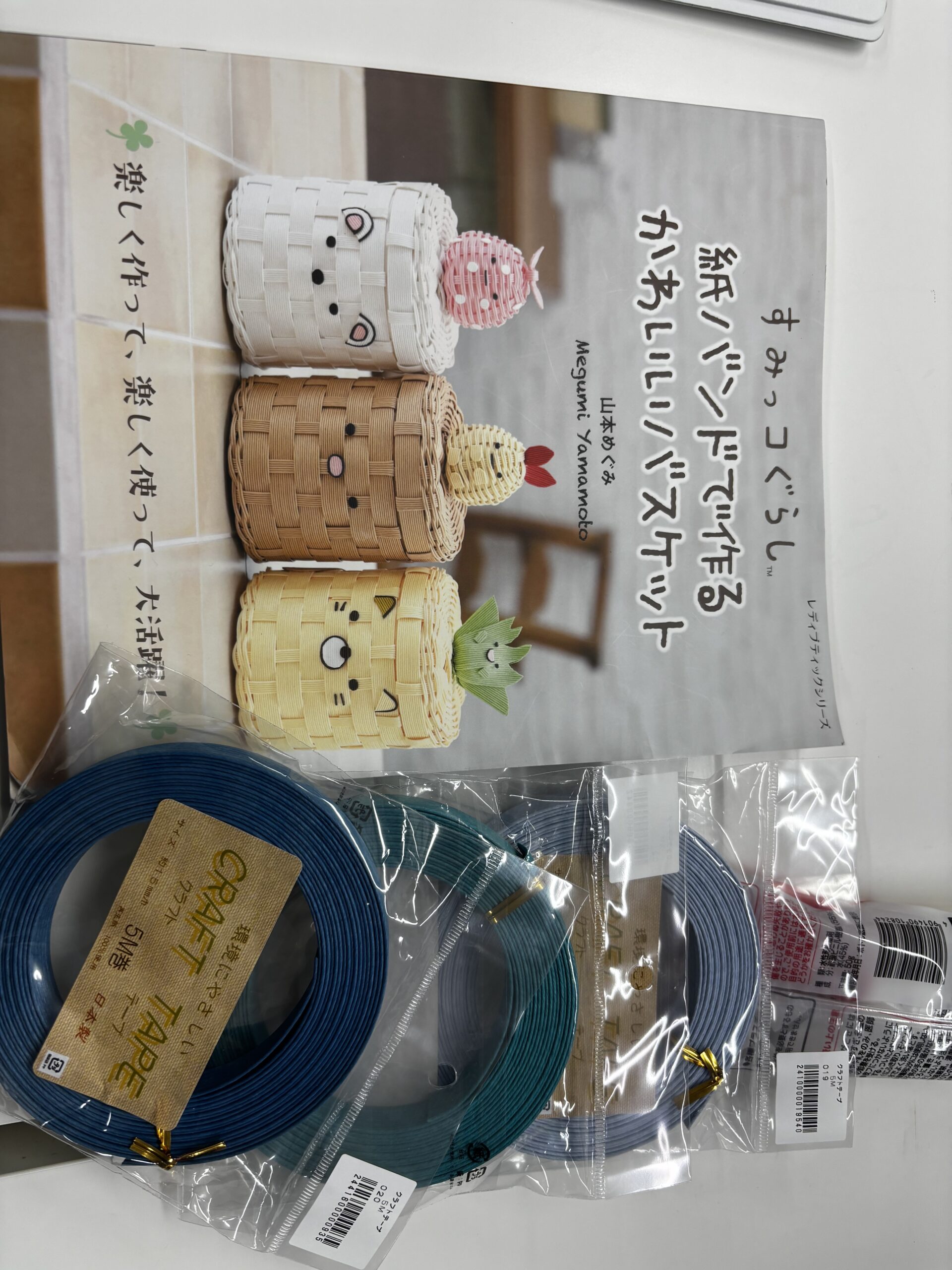 紙バンドのバスケット作りに使う本と青系のクラフトテープ